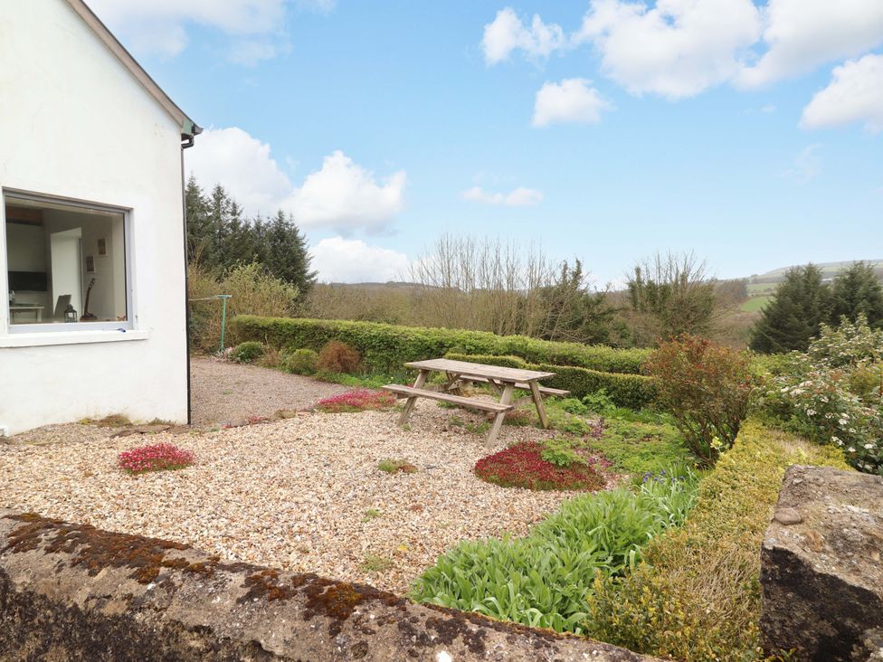 A garden with a picnic table and gravel at Turraheen Cashel