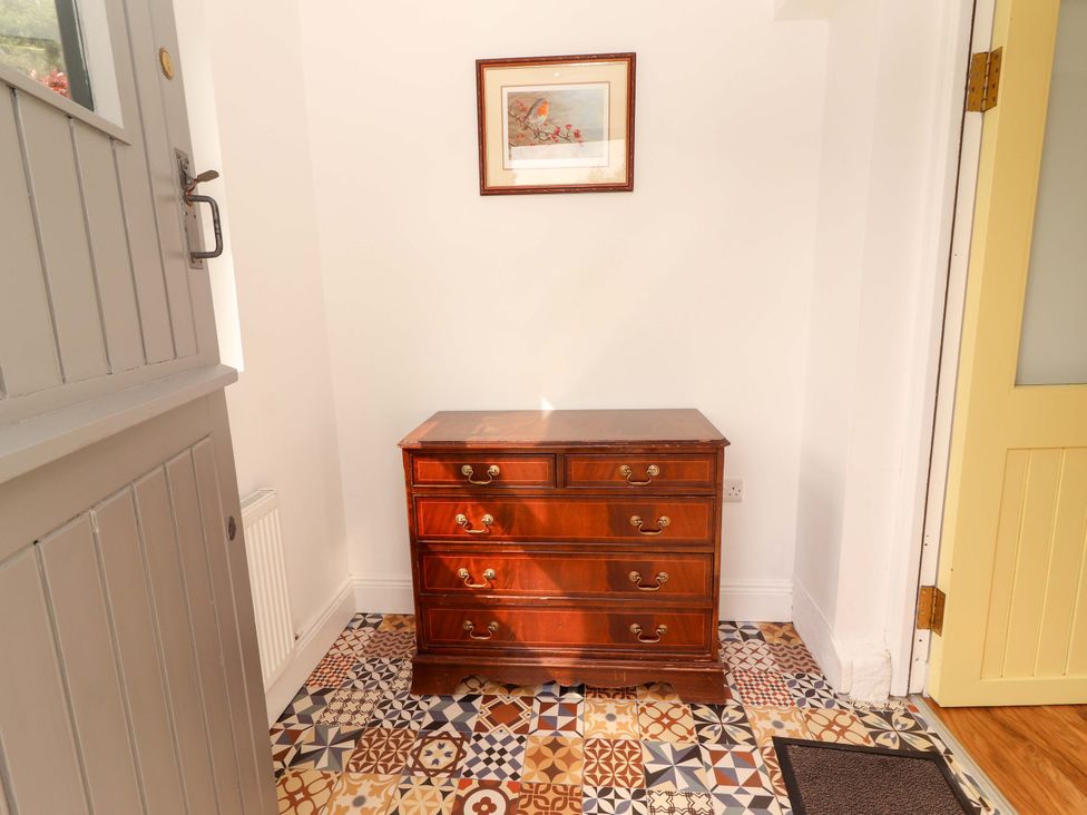 A hallway with a dresser and artwork on the wall at Artist’s Cottage in Cashel, County Tipperary