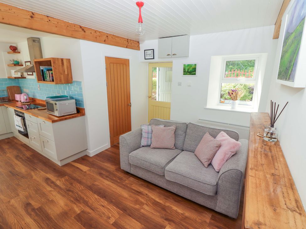 A living room with kitchen appliances at Artist’s Cottage in Cashel, County Tipperary