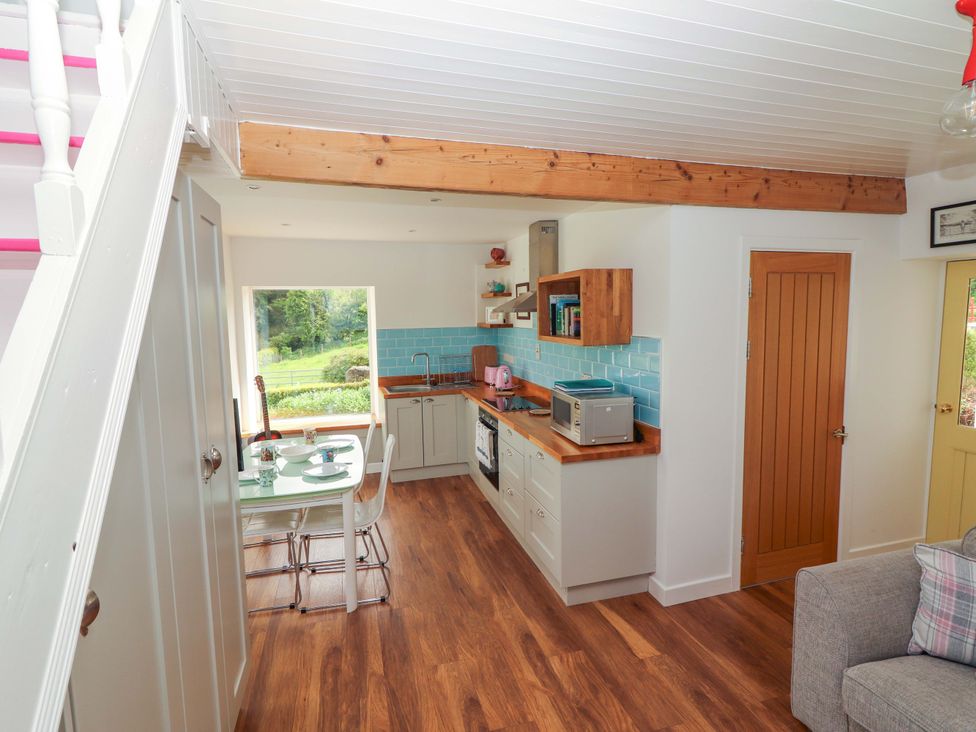 A kitchen with dining area and appliances at Artist’s Cottage Cashel, County Tipperary