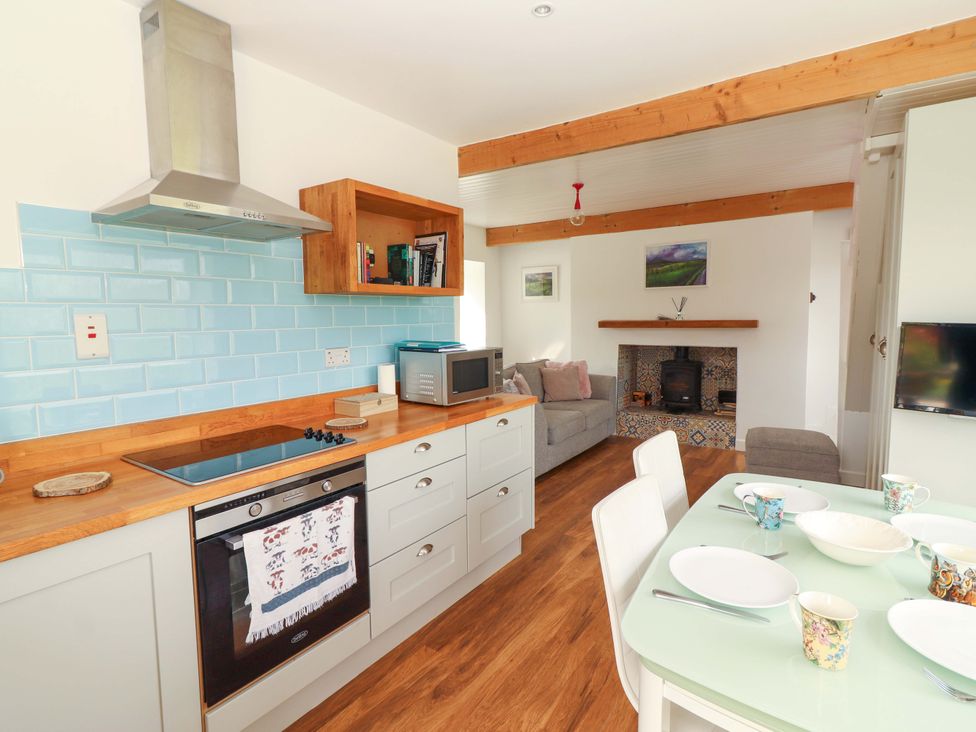 A kitchen with appliances and dining area at Artist’s Cottage in Cashel, County Tipperary