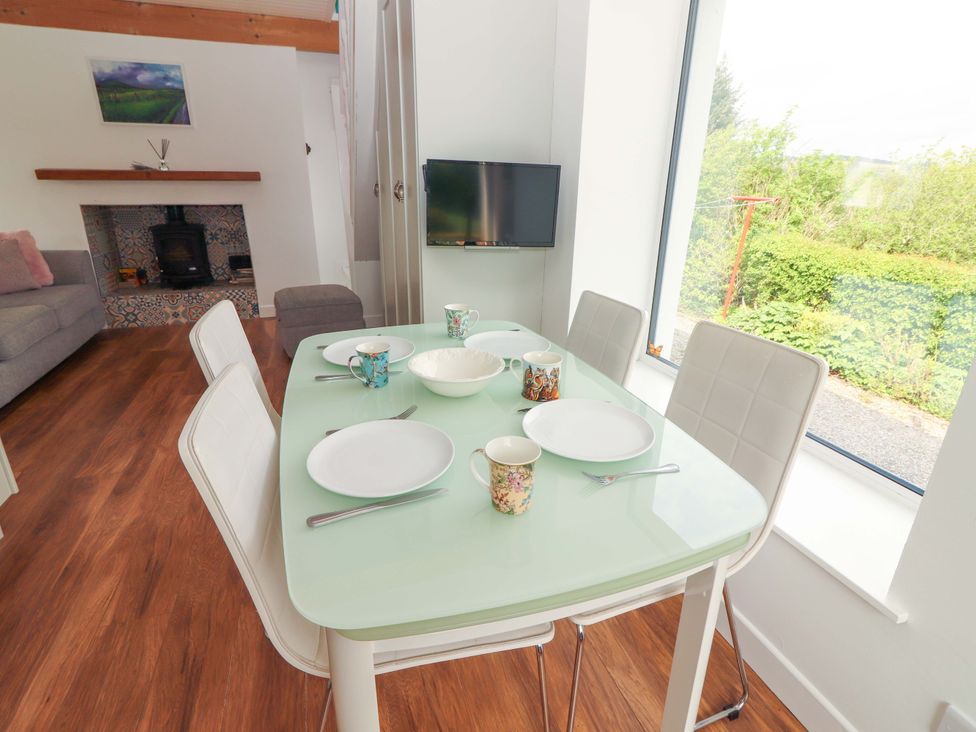A dining room with a table and chairs at Artist’s Cottage in Cashel, County Tipperary