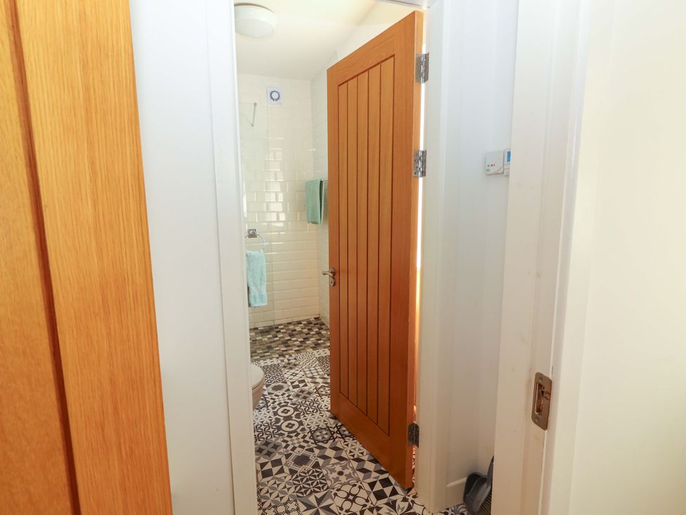 A bathroom with shower, toilet, and tiled floor at Artist’s Cottage, Cashel, County Tipperary