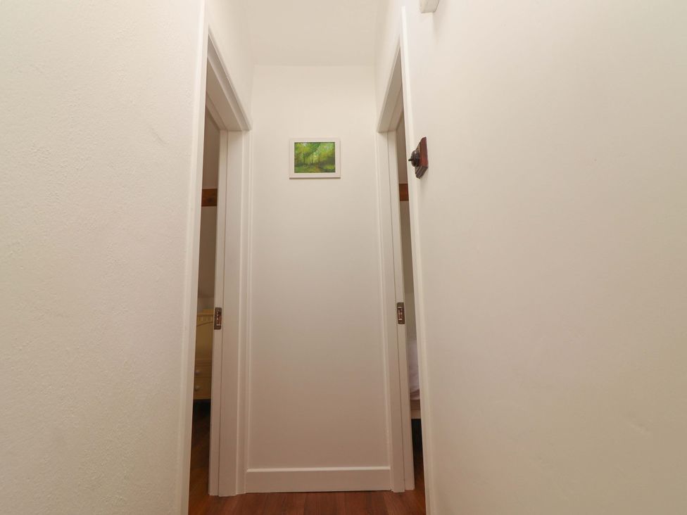 A hallway with doors and a picture on the wall at Artist’s Cottage in Cashel, County Tipperary