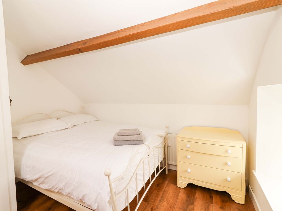 A bedroom with a bed and dresser at Artist’s Cottage in Cashel, County Tipperary