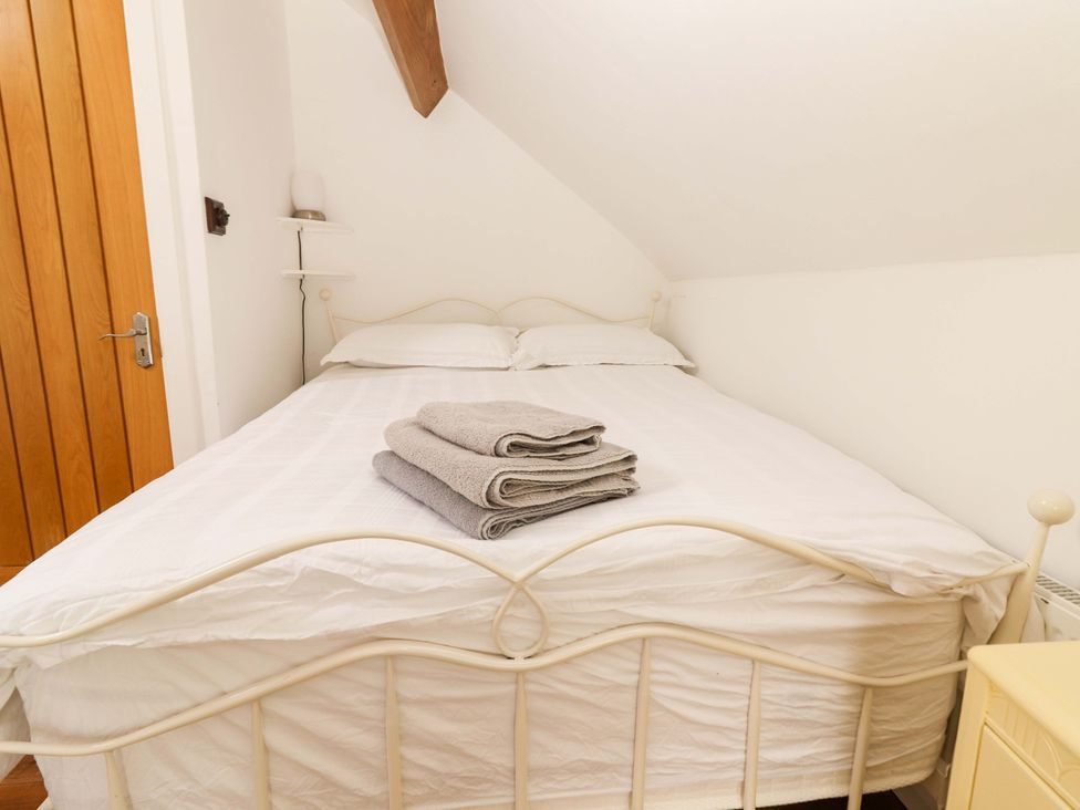 A bedroom with a bed and towels folded on top at Artist’s Cottage in Cashel, County Tipperary