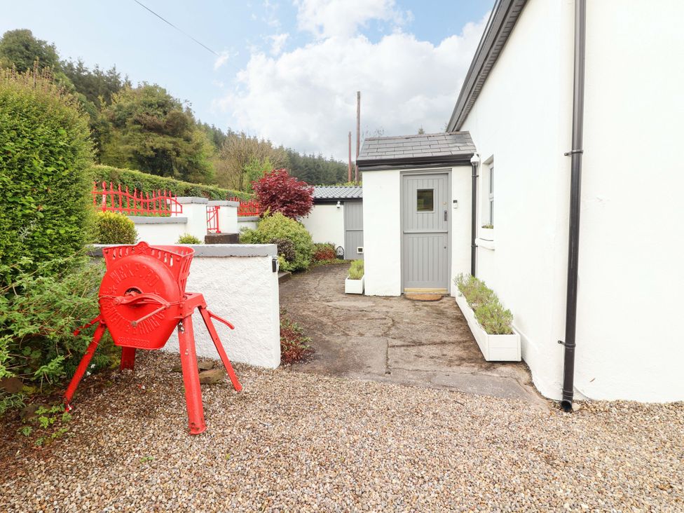 An outdoor area with a red decoration and a door at Artist’s Cottage in Cashel, County Tipperary