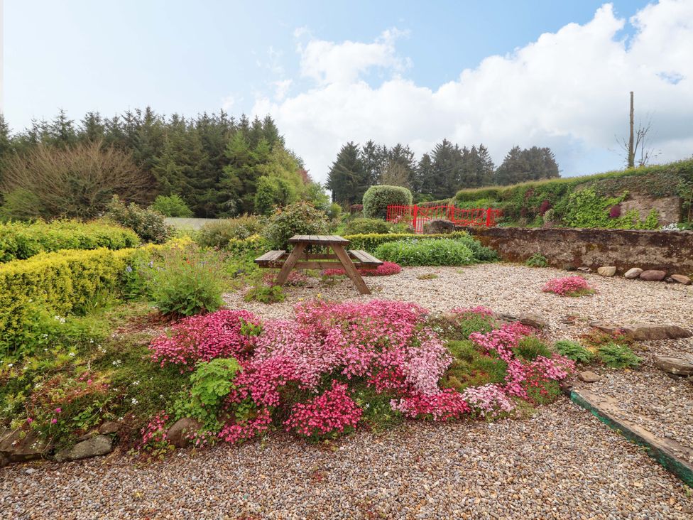 A garden with flowers and a seating area at Artist’s Cottage in Cashel, County Tipperary