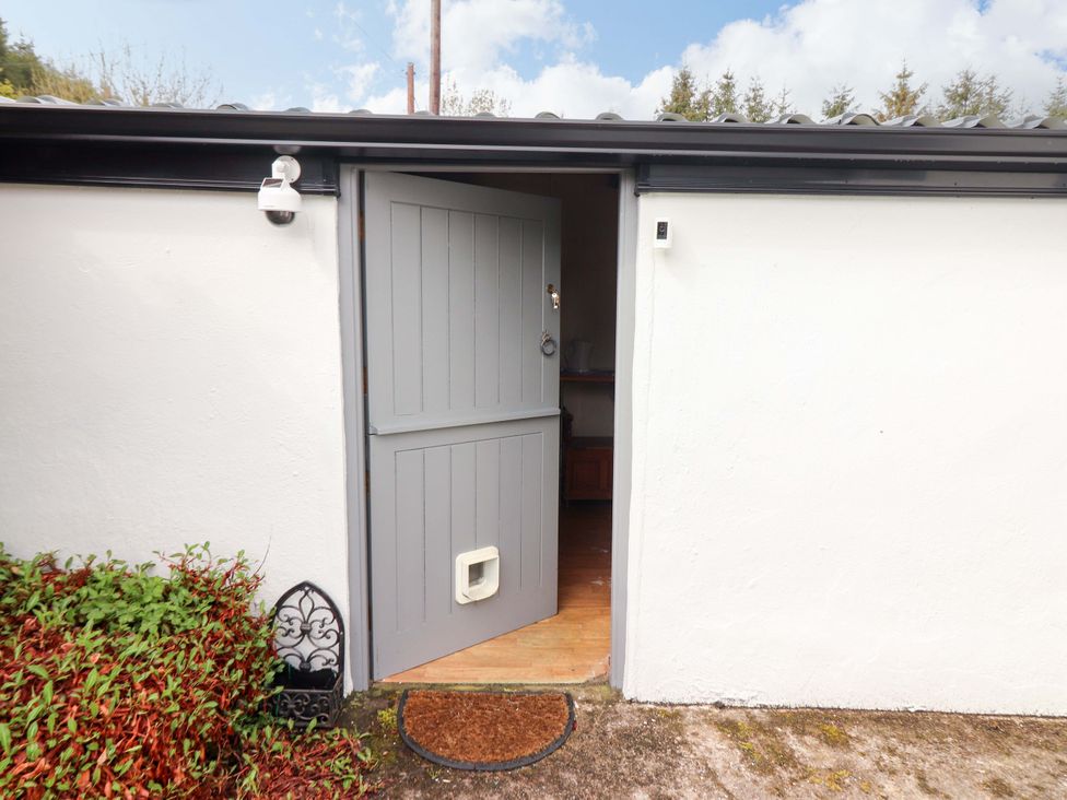 An entrance with a gray door and welcome mat at Artist’s Cottage, Cashel, County Tipperary