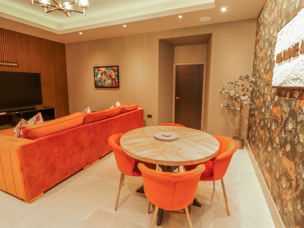 A living room with a sofa and dining table at Bounty Boutique on the Lakes Bowness-On-Windermere