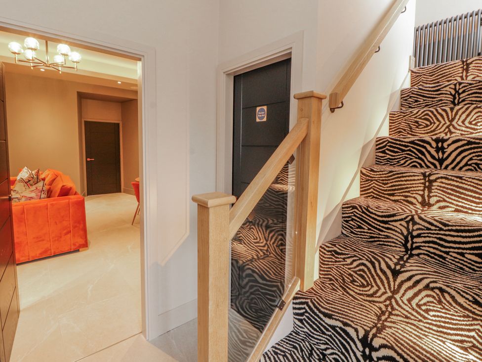 A hallway with a staircase and a view of a living room at Bounty Boutique on the Lakes Bowness-On-Windermere