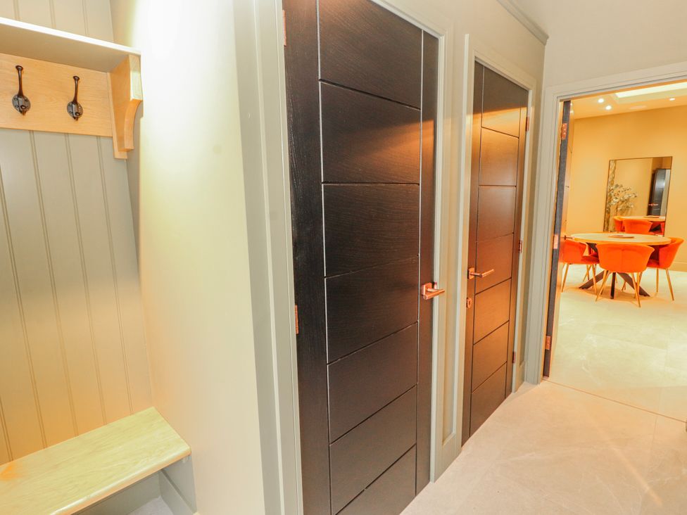 A hallway with doors and a bench at Bounty Boutique on the Lakes Bowness-On-Windermere