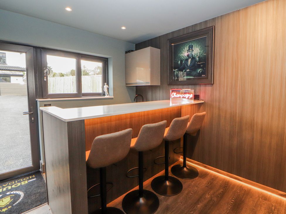 A kitchen with a bar counter and stools at Bounty Boutique on the Lakes Bowness-On-Windermere
