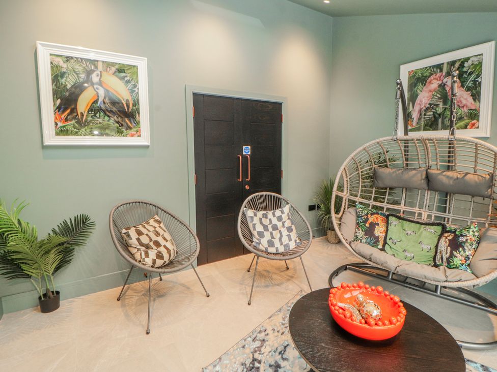 A seating area with two chairs and a swing chair at Bounty Boutique on the Lakes Bowness-On-Windermere