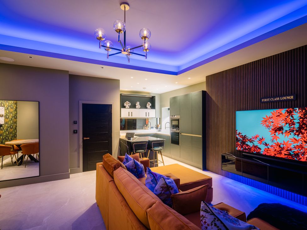 A living room with a television and sofa at Bounty Boutique on the Lakes Bowness-On-Windermere