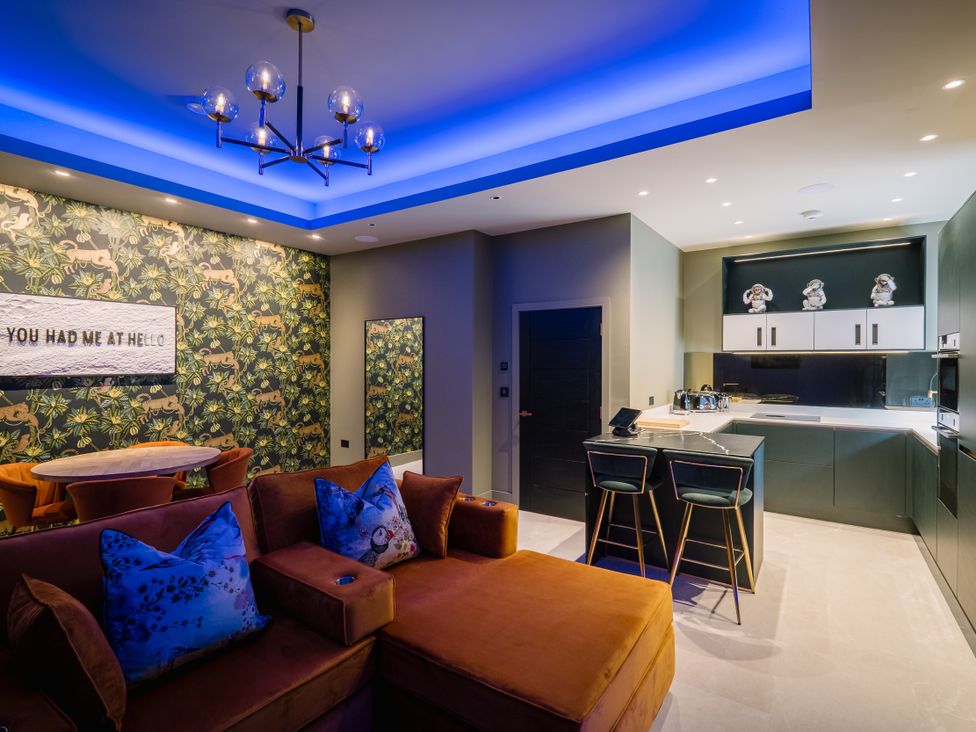 A living room with a couch and kitchen area at Bounty Boutique on the Lakes Bowness-On-Windermere