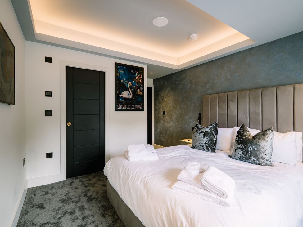 A bedroom with a bed and wall art at Bounty Boutique on the Lakes Bowness-On-Windermere