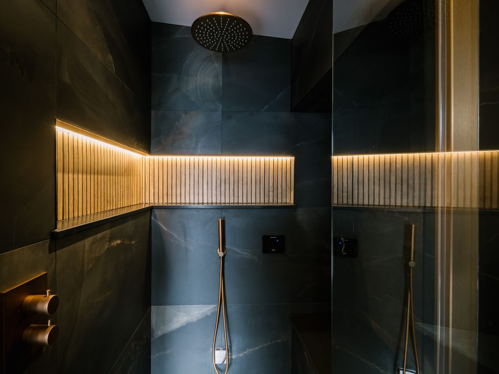 A bathroom with a shower and wall lighting at Bounty Boutique on the Lakes in Bowness-On-Windermere