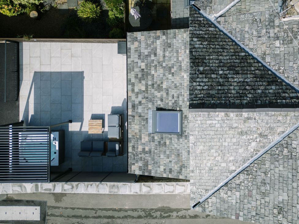 An outdoor patio with furniture and a hot tub at Bounty Boutique on the Lakes in Bowness-On-Windermere