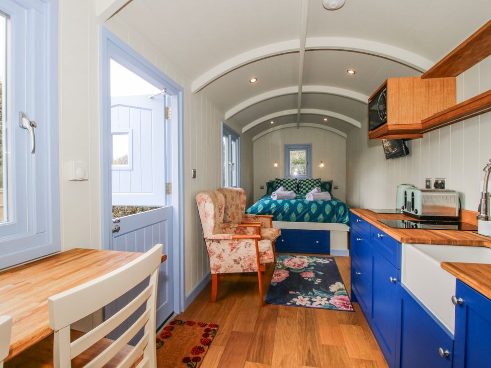 A bedroom with a bed and kitchen area at Skye in Clee Hill