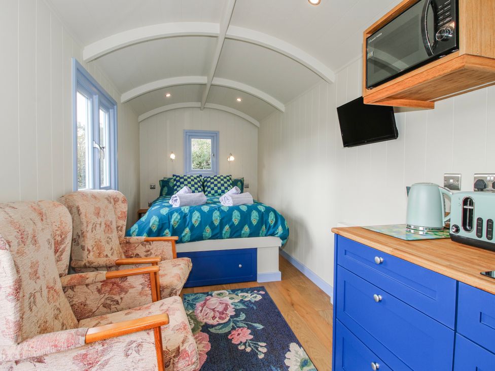 A bedroom with a bed and seating area at Skye in Clee Hill