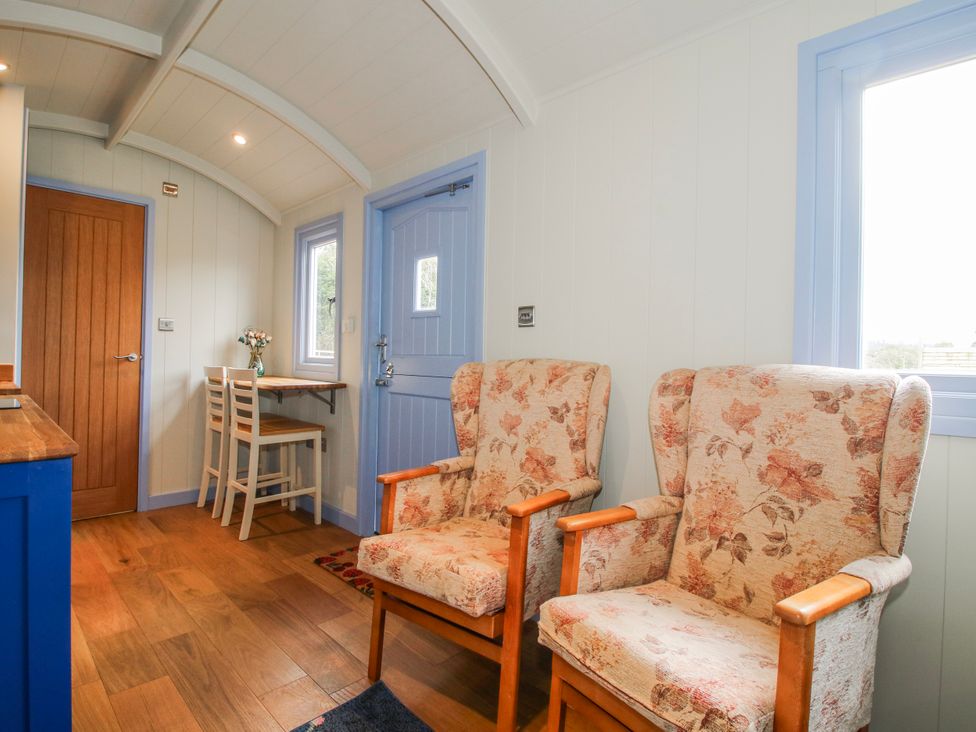 A living room with chairs and a table at Skye Clee Hill