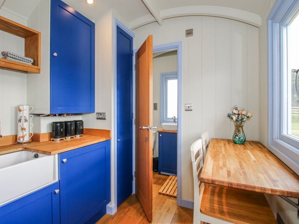A kitchen with a sink and dining table at Skye in Clee Hill