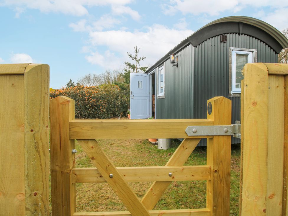 An outdoor view of a shed with a gate at Skye in Clee Hill