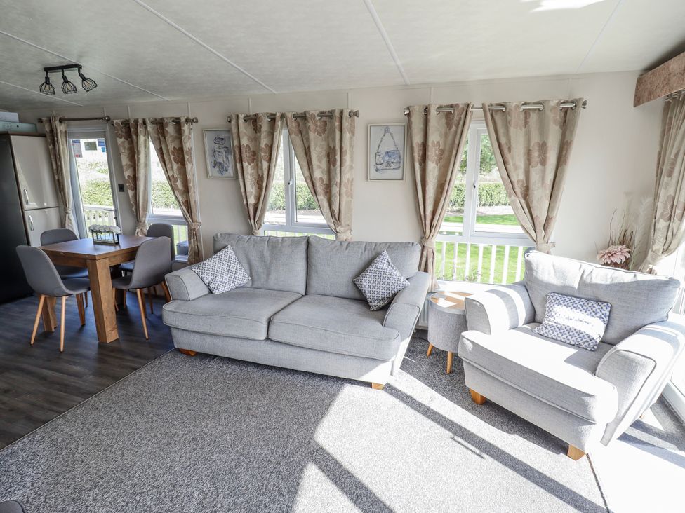 A living room with a sofa and dining table at 13 The Lakes in Mablethorpe