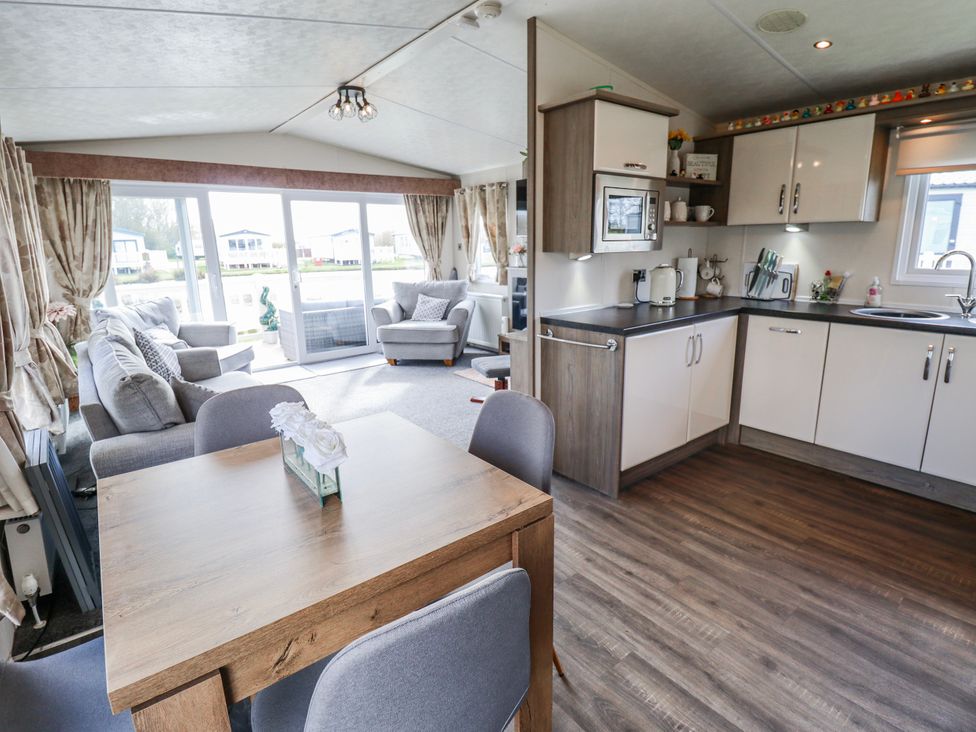A living room and kitchen area with furniture at 13 The Lakes Mablethorpe