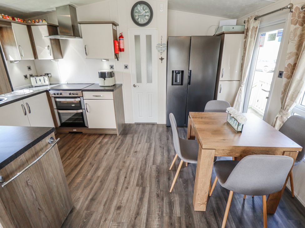A kitchen with dining table and chairs at 13 The Lakes in Mablethorpe