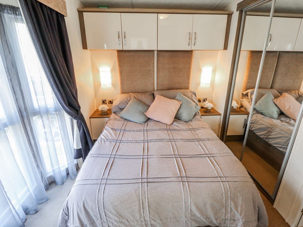 A bedroom with a double bed and wardrobe at 13 The Lakes in Mablethorpe