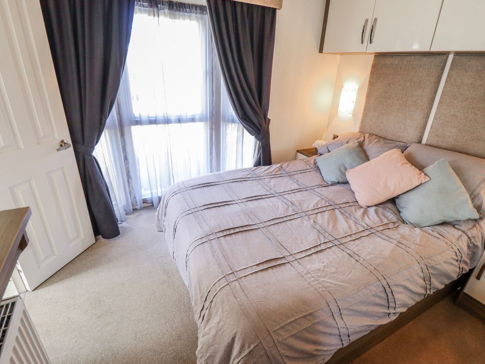 A bedroom with a bed and window at 13 The Lakes in Mablethorpe