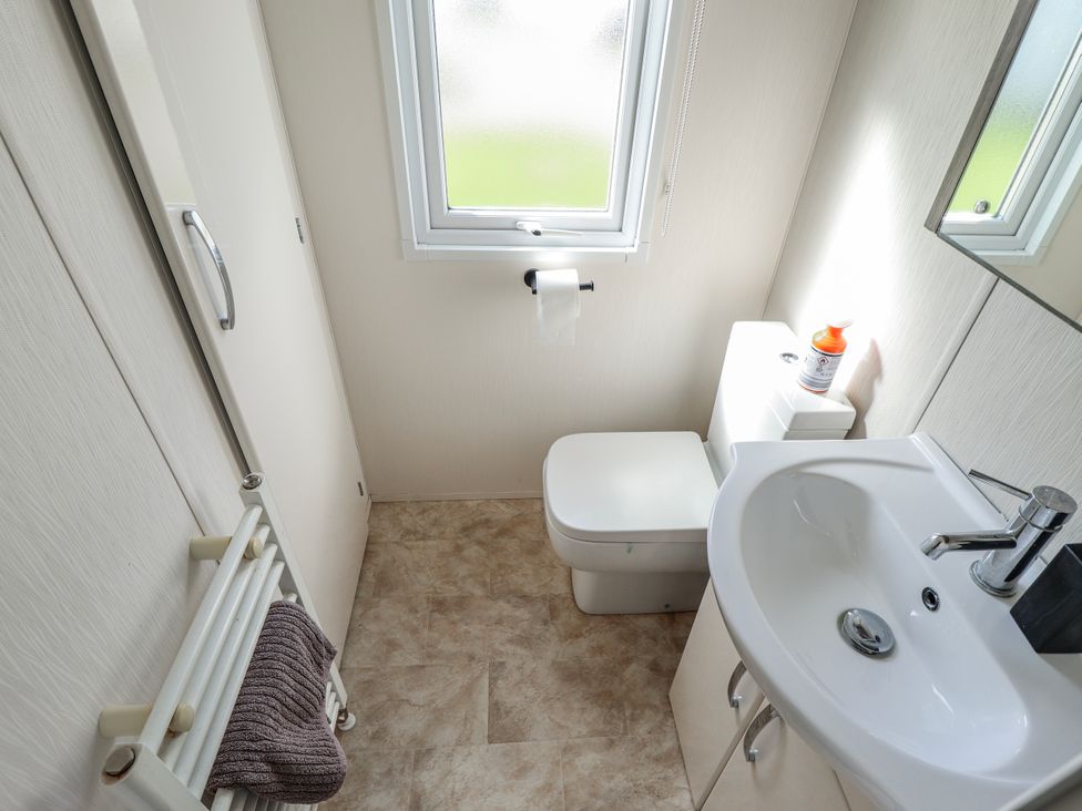 A bathroom with a toilet and sink at 13 The Lakes Mablethorpe