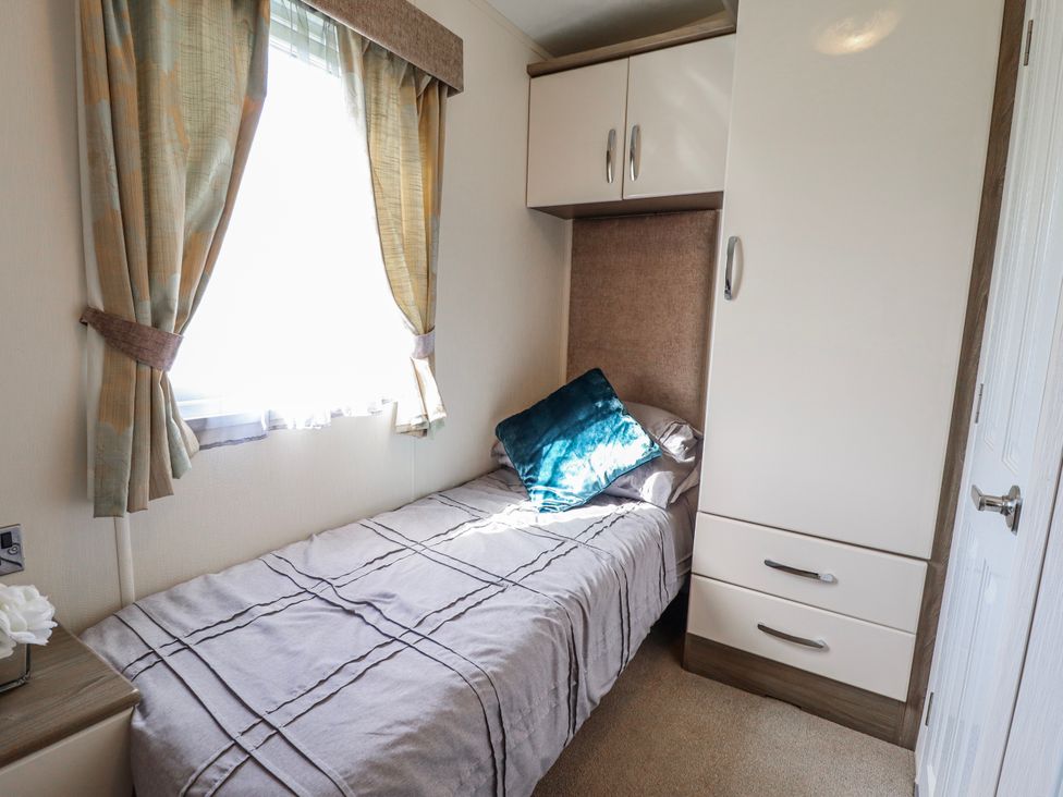 A bedroom with a single bed and wardrobe at 13 The Lakes in Mablethorpe