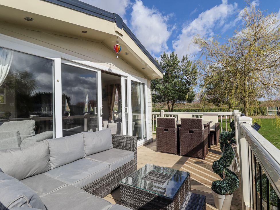 An outdoor seating area with sofa, table and chairs at 13 The Lakes in Mablethorpe
