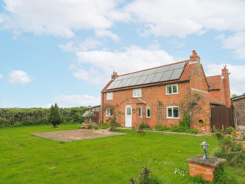 An outdoor view of a house with a garden and solar panels at Brecks Cottage Moorhouse near Tuxford