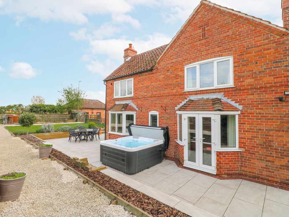 An outdoor area with a hot tub and dining set at Brecks Cottage Moorhouse near Tuxford