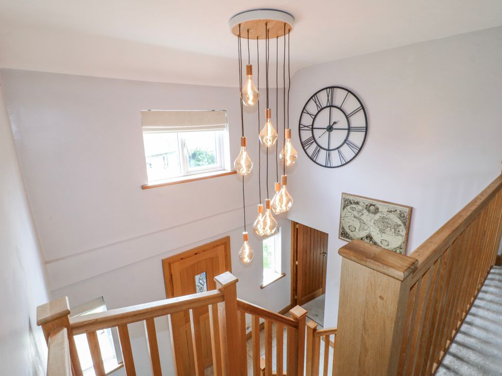 A staircase with a light fixture in a hallway at Brecks Cottage in Moorhouse near Tuxford