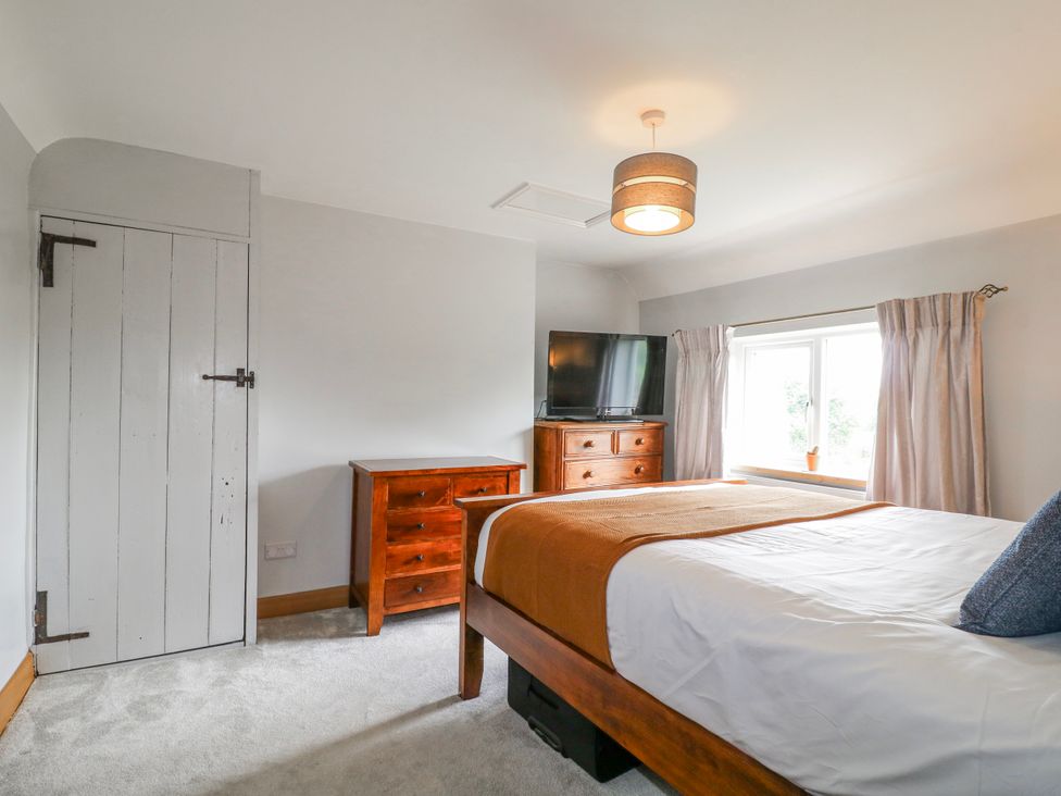 A bedroom with a bed, chest of drawers, and television at Brecks Cottage Moorhouse near Tuxford