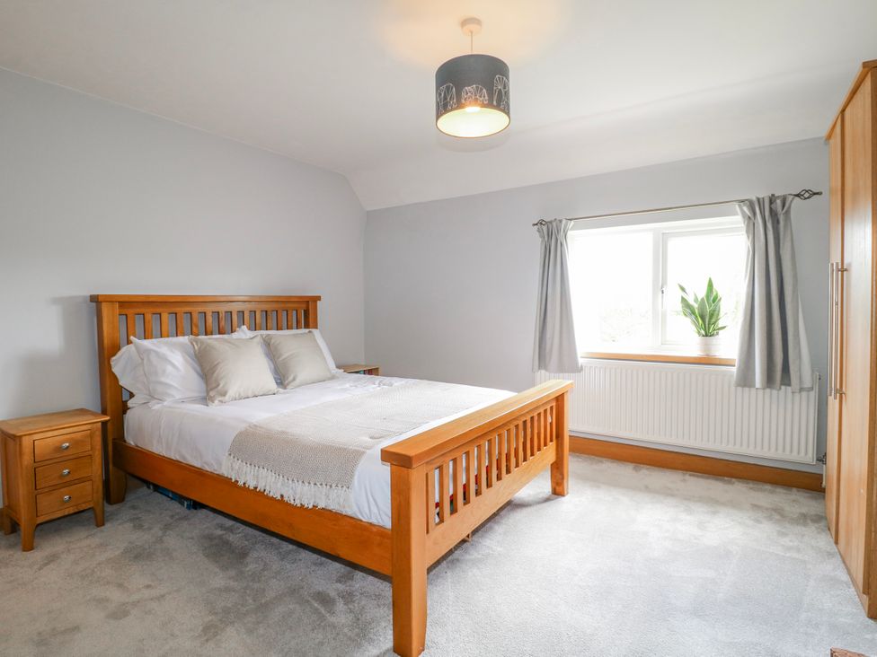 A bedroom with a bed and nightstand at Brecks Cottage near Moorhouse Tuxford