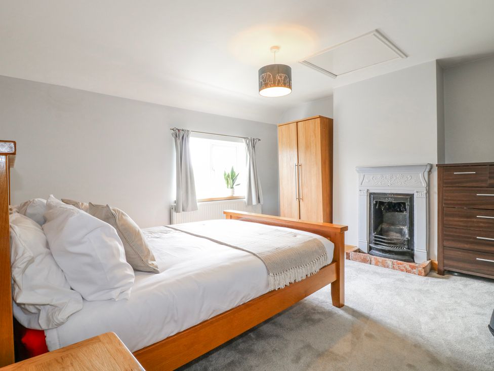 A bedroom with a bed and wardrobe at Brecks Cottage Moorhouse near Tuxford