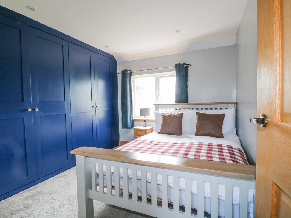 A bedroom with a bed and wardrobe at Brecks Cottage Moorhouse near Tuxford
