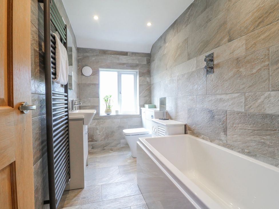 A bathroom with a bathtub, toilet, and sink at Brecks Cottage Moorhouse near Tuxford