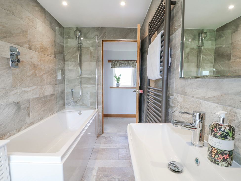A bathroom with a bathtub and shower at Brecks Cottage in Moorhouse near Tuxford