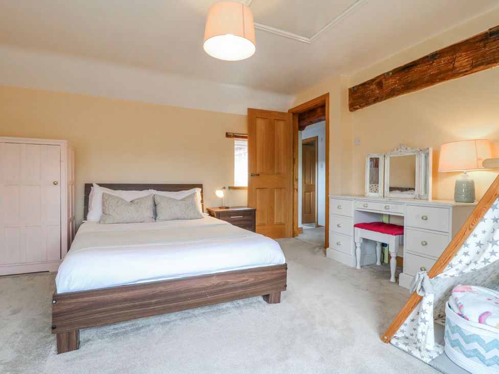 A bedroom with a bed and a dressing table at Brecks Cottage Moorhouse near Tuxford