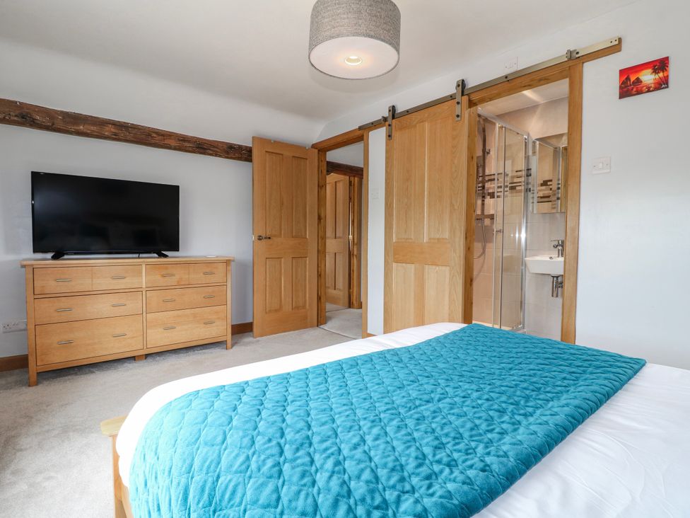 A bedroom with a bed, television, and adjoining bathroom at Brecks Cottage Moorhouse near Tuxford