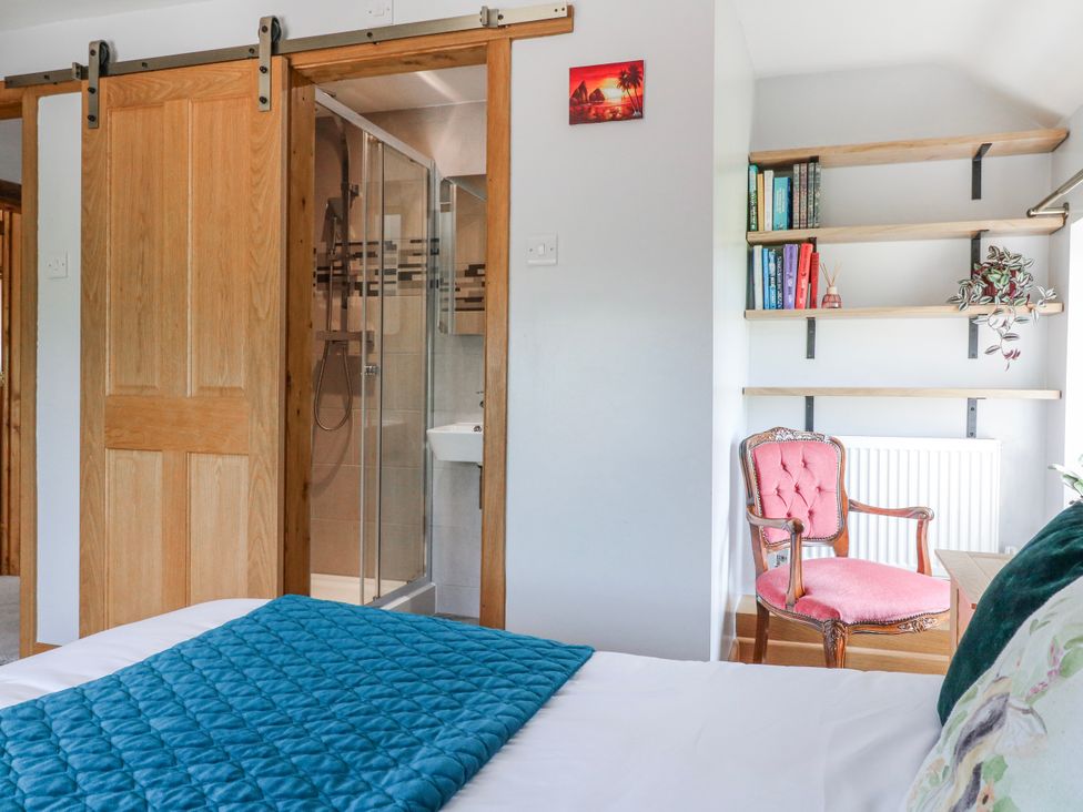A bedroom with a shower and wooden door at Brecks Cottage Moorhouse near Tuxford
