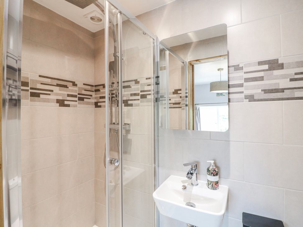 A bathroom with a shower enclosure and a sink at Brecks Cottage in Moorhouse near Tuxford