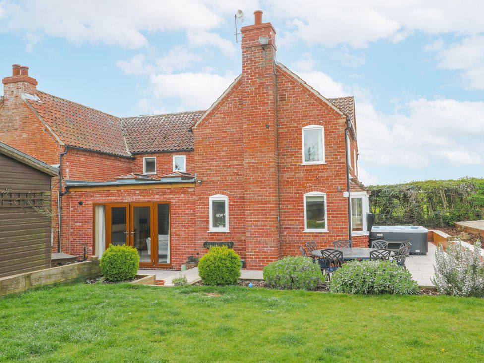 An outdoor view of a house with a garden and patio at Brecks Cottage Moorhouse near Tuxford